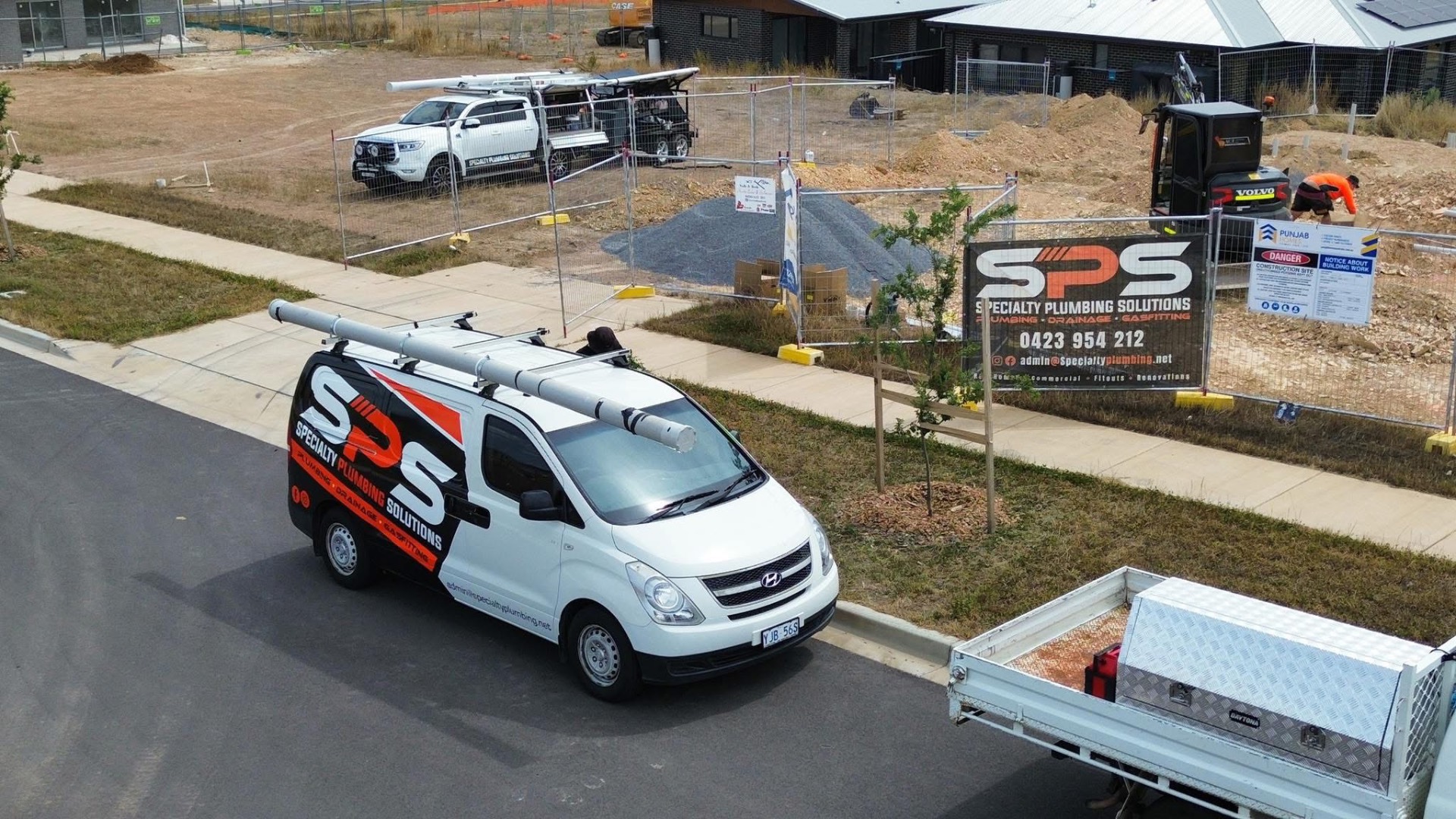 Aerial view of an SPS Specialty Plumbing Solutions van and signage on a Canberra construction site